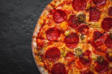 Mozzarella peynirli Pepperoni Pizza, salam, domates sosu, biber, baharat. Koyu gri arka planda İtalyan pizzası