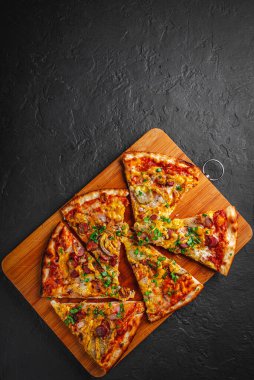 Mozzarella peynirli bir dilim pizza, salam, domates sosu, biber, sosis, salatalık turşusu ve soğan. Koyu gri arka planda İtalyan pizzası