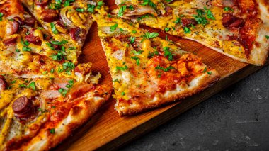 Mozzarella peynirli bir dilim pizza, salam, domates sosu, biber, sosis, salatalık turşusu ve soğan. Koyu gri arka planda İtalyan pizzası