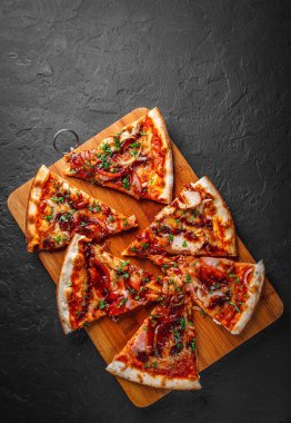 Tavuk ve barbekü soslu bir dilim pizza. Koyu gri arka planda İtalyan pizzası