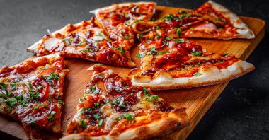 Tavuk ve barbekü soslu bir dilim pizza. Koyu gri arka planda İtalyan pizzası