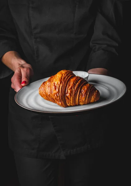 Chef Traje Negro Sostiene Sus Manos Plato Con Croissant Sobre —  Fotos de Stock