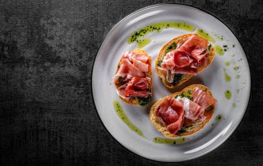 Prosciutto ve tabakta pesto sosu.