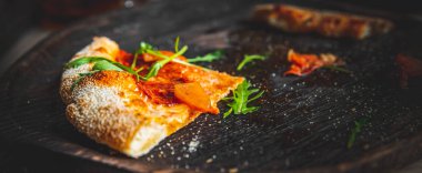 Kafedeki siyah tahta üzerinde son dilim pizza.