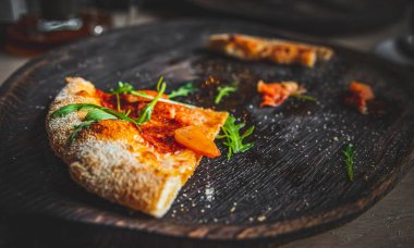 Kafedeki siyah tahta üzerinde son dilim pizza.