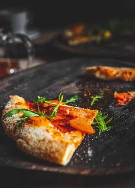 Kafedeki siyah tahta üzerinde son dilim pizza.