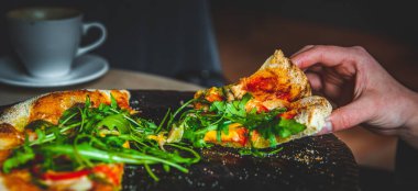 Kadın El, Mozzarella peynirli, salamlı, domatesli, biberli, baharatlı ve taze roka aromalı Pepperoni Pizza alır.