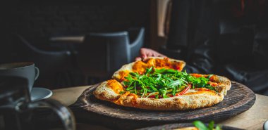 Kadın El, Mozzarella peynirli, salamlı, domatesli, biberli, baharatlı ve taze roka aromalı Pepperoni Pizza alır.