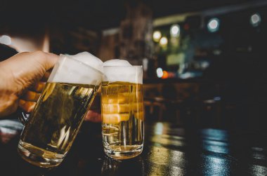 İki bardak biranın yakın çekim görüntüsü. Barda ya da barda bira bardakları tıkırdıyor.