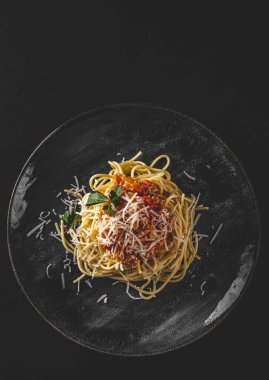 Geleneksel makarna bolonez siyah ahşap masa arkasında tabak