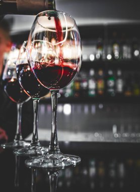 Barmen, kafede ya da barda bardağa kırmızı şarap dolduruyor