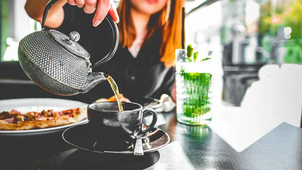 Mano Mujer Con Tetera Metal Verter Negro Taza Vidrio Negro — Foto de Stock