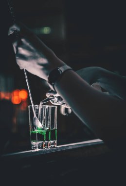 Barmen renkli fotoğraflardan koleksiyon yapıyor. Barda bir çift kokteyl.