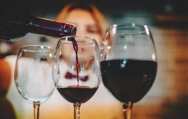 Barmen, kafede ya da barda bardağa kırmızı şarap dolduruyor