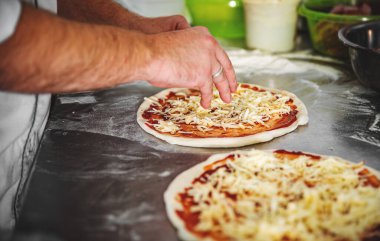 Mutfakta pizza yapan şef fırıncının eli. Pizza yapma süreci. İtalyan pizzası pişirmek