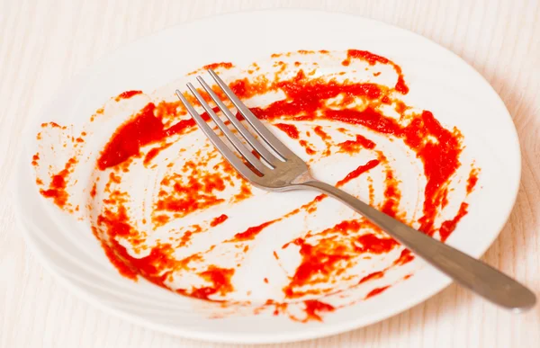 Βρώμικο πιάτο στο τραπέζι. Σάλτσα ντομάτας smeared σε ένα πιάτο. — Φωτογραφία Αρχείου