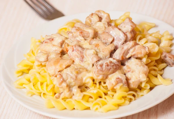 Sliced fried chicken in a creamy sauce. with fusilli pasta — Stock Photo, Image