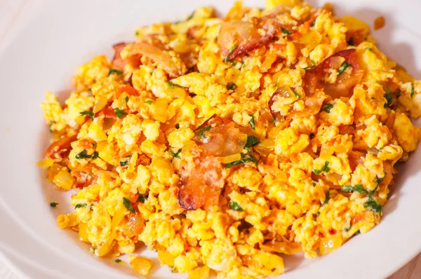 Scrambled eggs with tomato and bacon — Stock Photo, Image