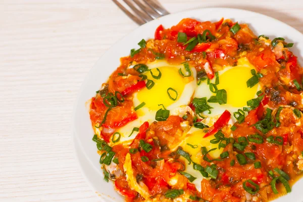 Eggs in a sauce of tomatoes, chili peppers, and onions — Stock Photo, Image