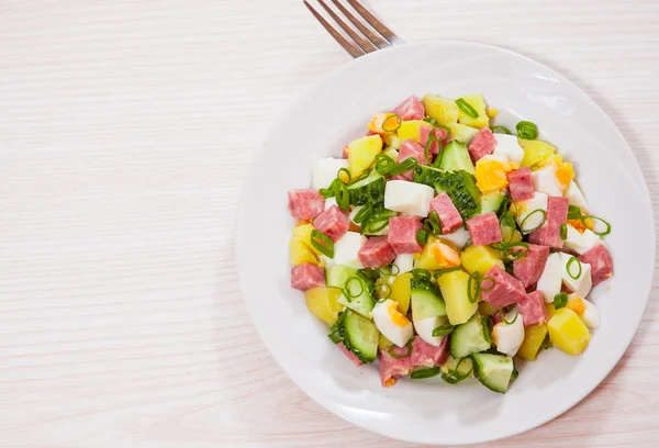 Verse salade met aardappel, ei, salami, komkommer en groene ui — Stockfoto