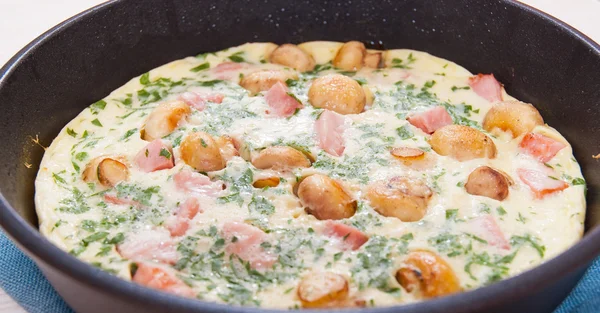 Omelet with mushrooms, ham and cheese in a frying pan — Stock Photo, Image