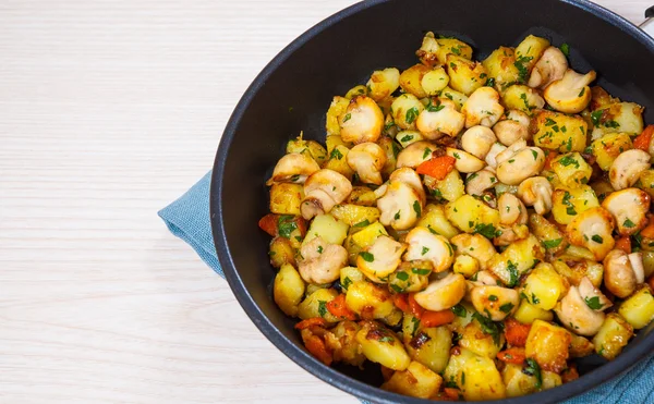 Batata frita com cogumelos em uma panela de ato de fritar — Fotografia de Stock