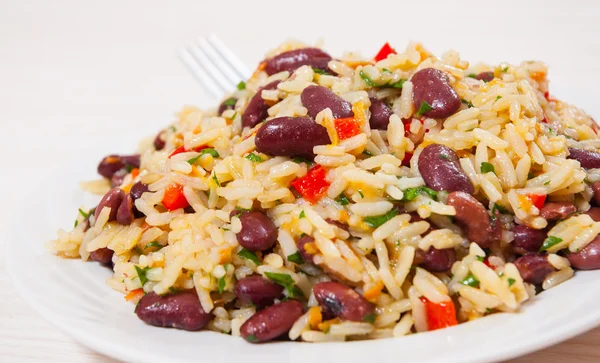 Arroz com feijão vermelho e legumes no prato — Fotografia de Stock