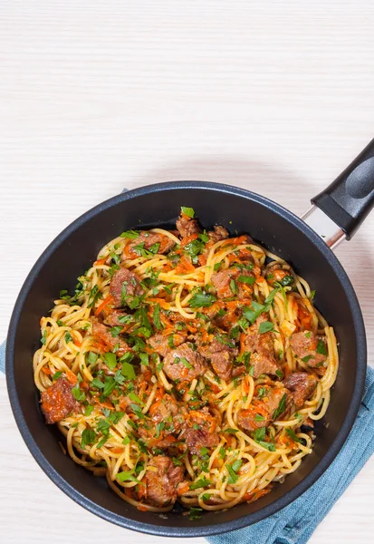 Pieces of meat and vegetables with spaghetti in a frying pan — Stock Photo, Image