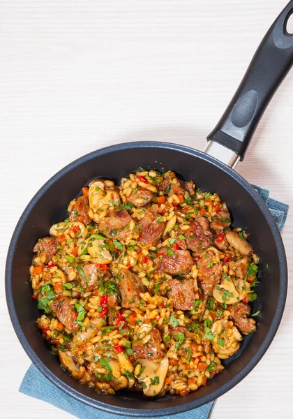 Reis mit Fleisch, Gemüse und Pilzen in der Pfanne — Stockfoto