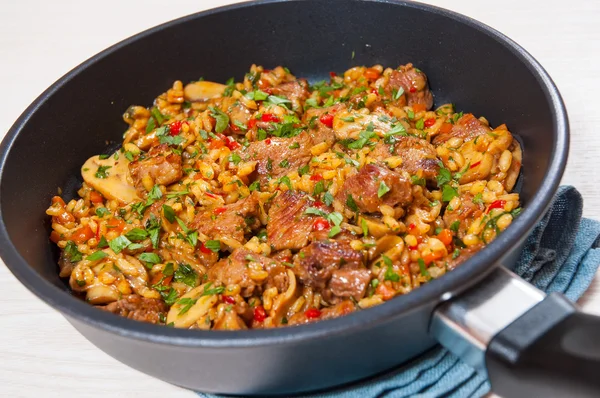 Reis mit Fleisch, Gemüse und Pilzen in der Pfanne — Stockfoto