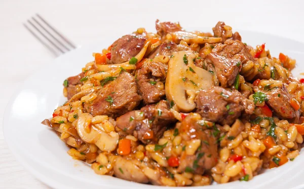 Arroz com carne, legumes e cogumelos no prato — Fotografia de Stock