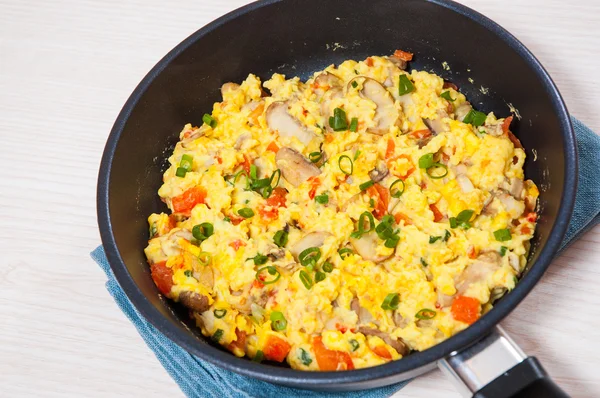 Huevos revueltos con setas y verduras en una sartén —  Fotos de Stock