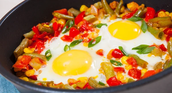 Ovos fritos com verduras variadas em uma panela de ato de fritar — Fotografia de Stock