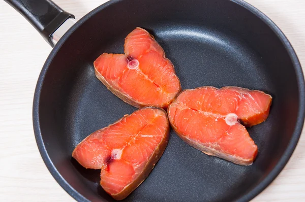 Carne de salmão em uma panela de ato de fritar — Fotografia de Stock