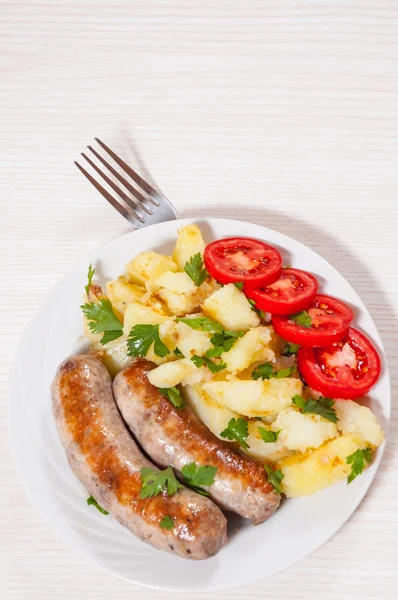 Batatas com linguiças no prato — Fotografia de Stock