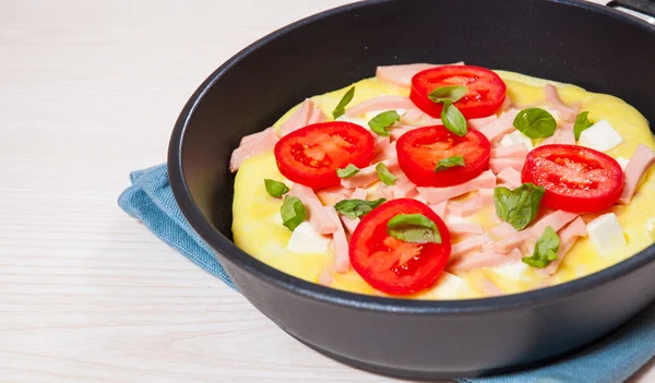 Omelett med skinka och ost i en stekpanna — Stockfoto