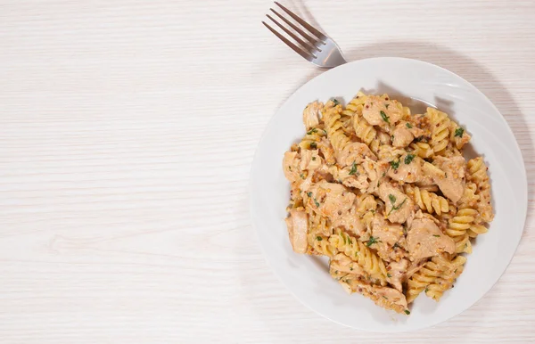 Plátky filé smažené kuřecí ve smetanové a hořčicovou omáčkou. s těstoviny fusilli — Stock fotografie