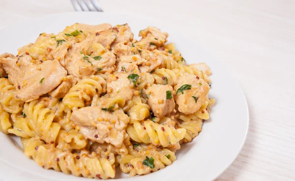 Sliced fried chicken fillet in a creamy and mustard sauce. with fusilli pasta — Stock Photo, Image