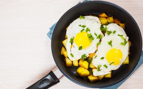 Spiegeleier mit Kartoffeln in der Pfanne — Stockfoto