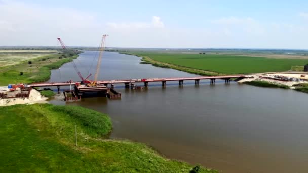 Vista aérea de la construcción de un puente que cruza el río. — Vídeos de Stock