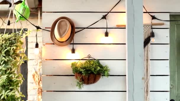 Un sombrero marrón cuelga en la pared de una casa de campo en el pueblo. diseño vintage — Vídeo de stock