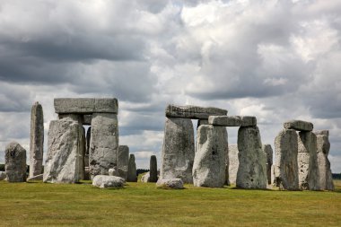 Stonehenge mavi gökyüzünün altında yeşil çimenlerin üzerinde tarihi bir site. stonehen
