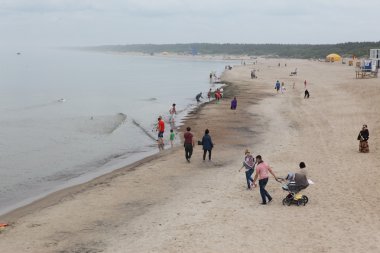Palanga kumsalda yürüyen insanlar