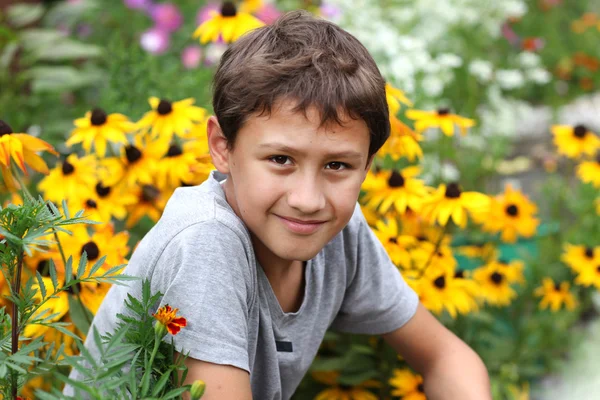 Мальчик против летнего цветка — стоковое фото