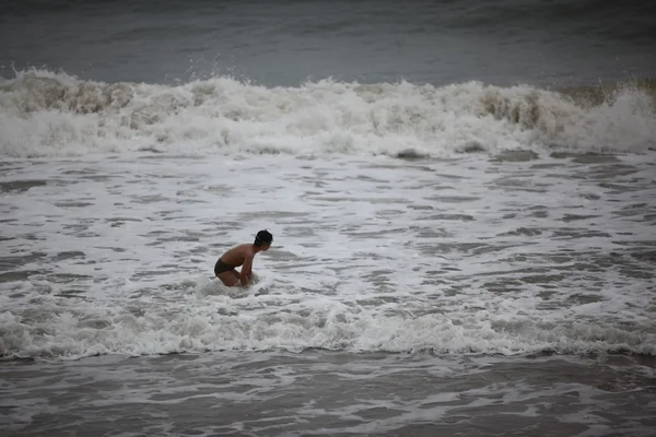 Pojke spelar i havets vågor — Stockfoto