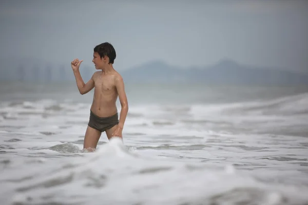 Jongen speelt in oceaan golven — Stockfoto