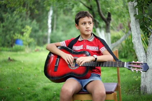 Хлопчик з гітарою на відкритому повітрі — стокове фото