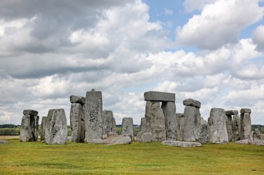 Stonehenge historic site on green grass under blue sky. Stonehen clipart