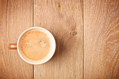 Kahve fincanı ahşap masada.