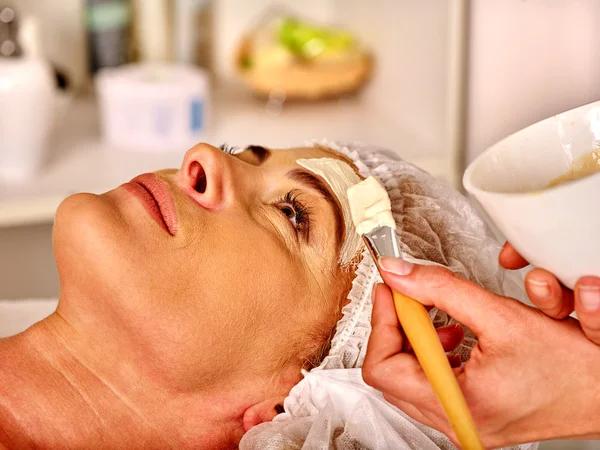 Mulher de meia-idade recebe massagem facial no salão de spa . — Fotografia de Stock